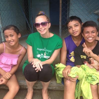 A Projects Abroad volunteer takes a picture with children at a placement in Samoa A volunteers takes a picture with children at her placement in Samoa
